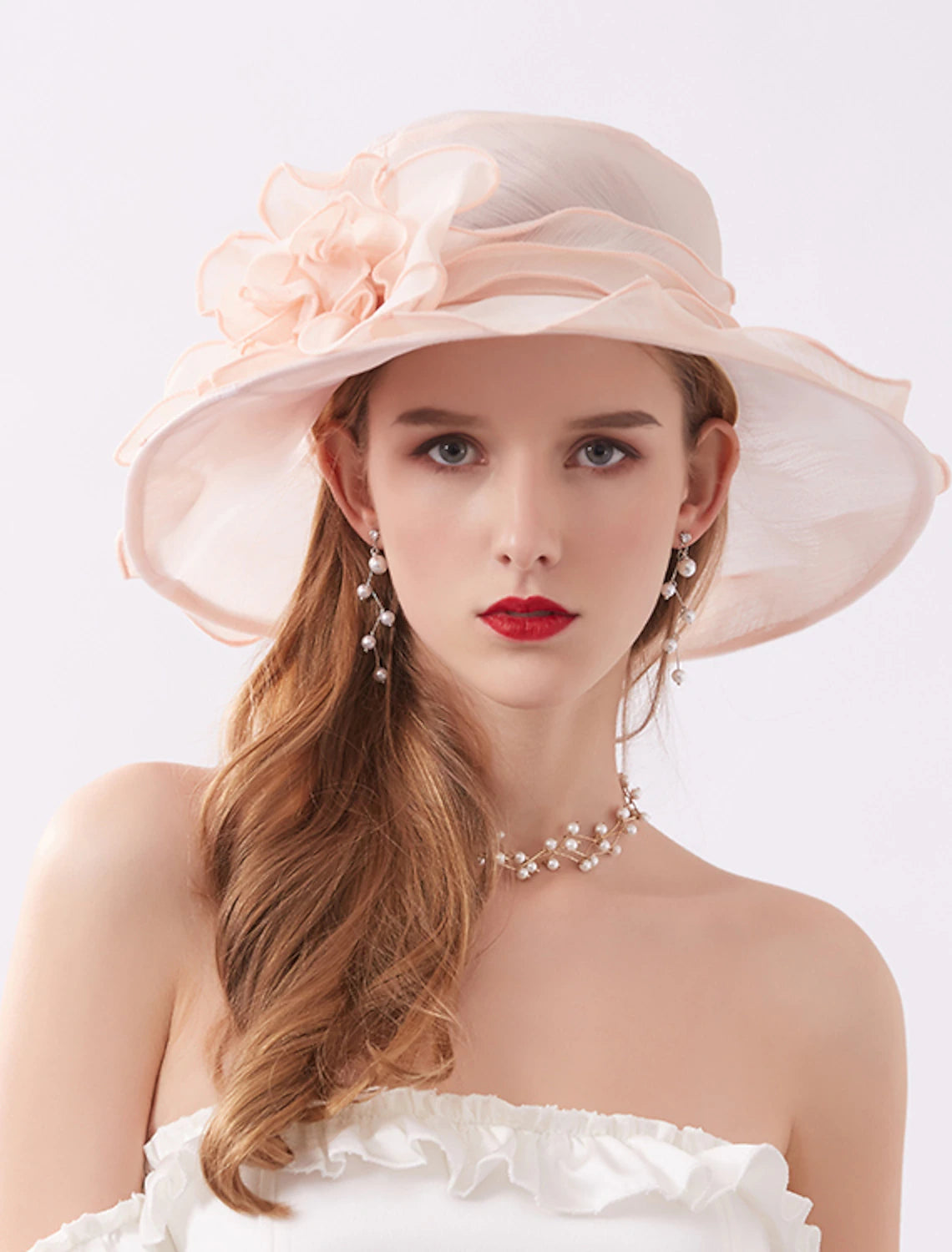 Woman wearing an elegant white organza sun hat with floral appliques.
