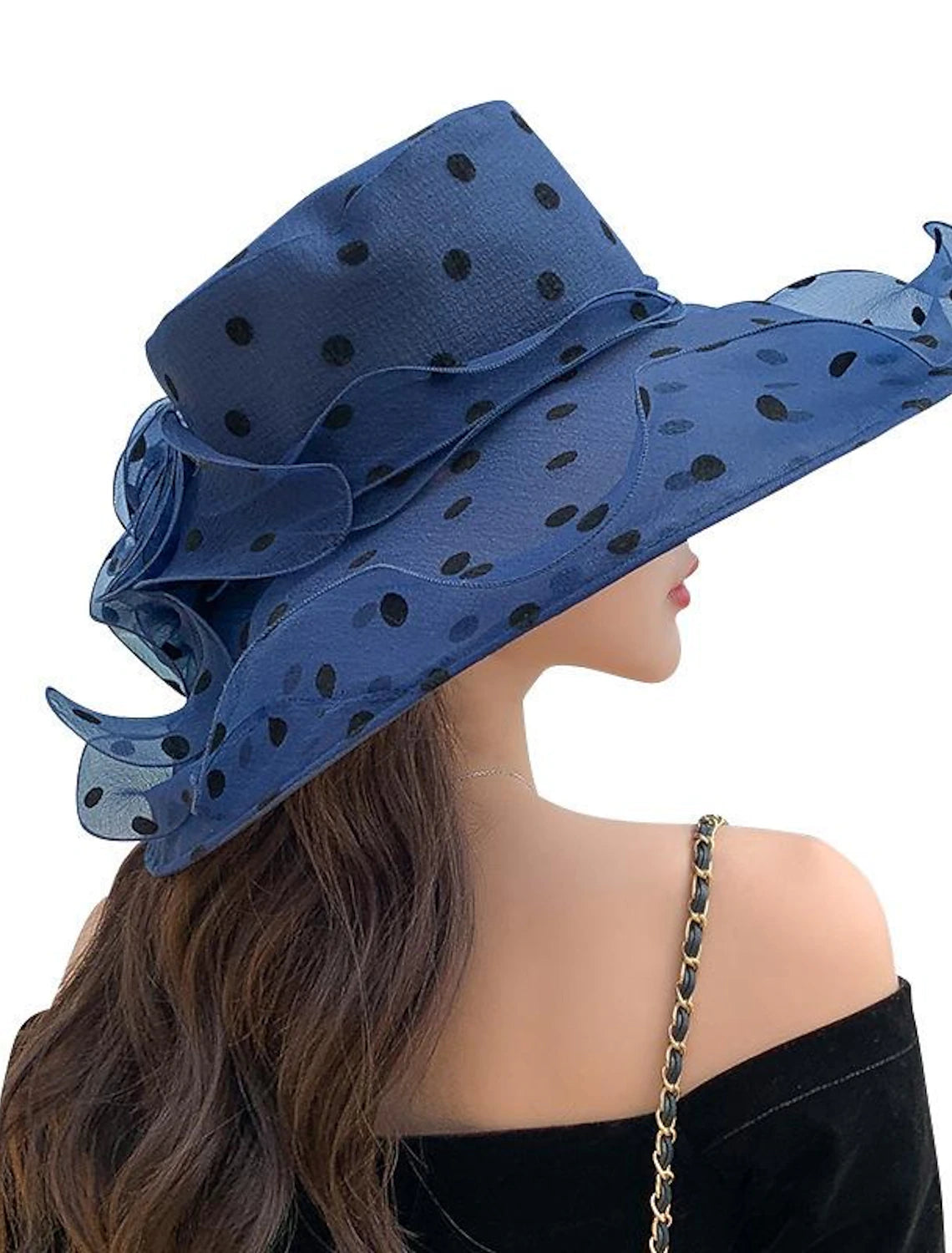 Side view of a woman wearing a chic tulle sun hat with a wide brim.
