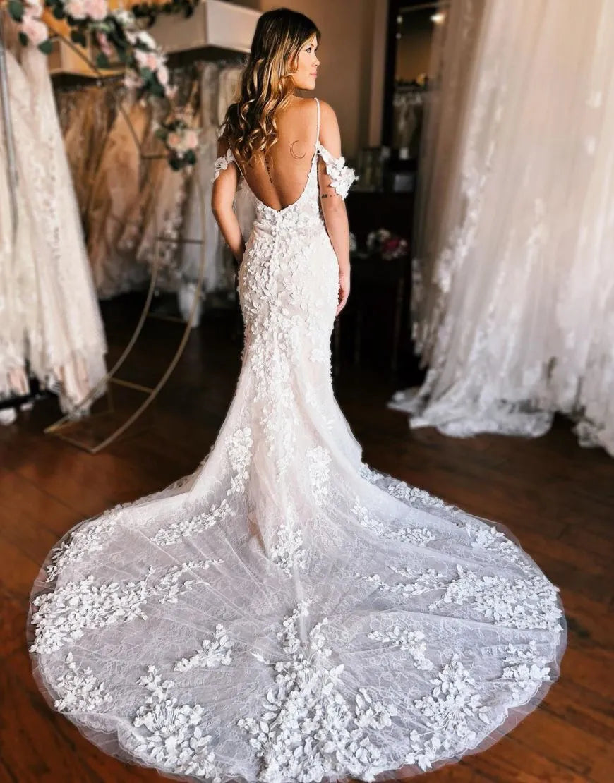 Back view of a mermaid wedding gown showing the elegant train and off-shoulder design.