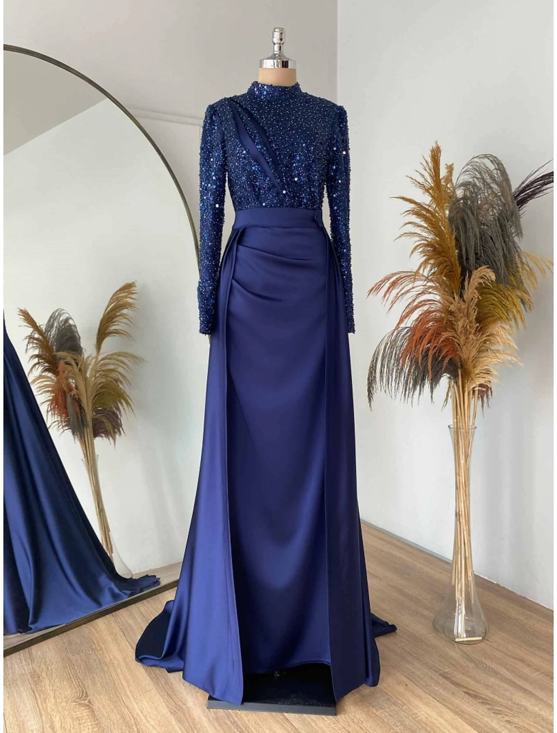 Full length view of a red sheath gown with pleats and ruching.