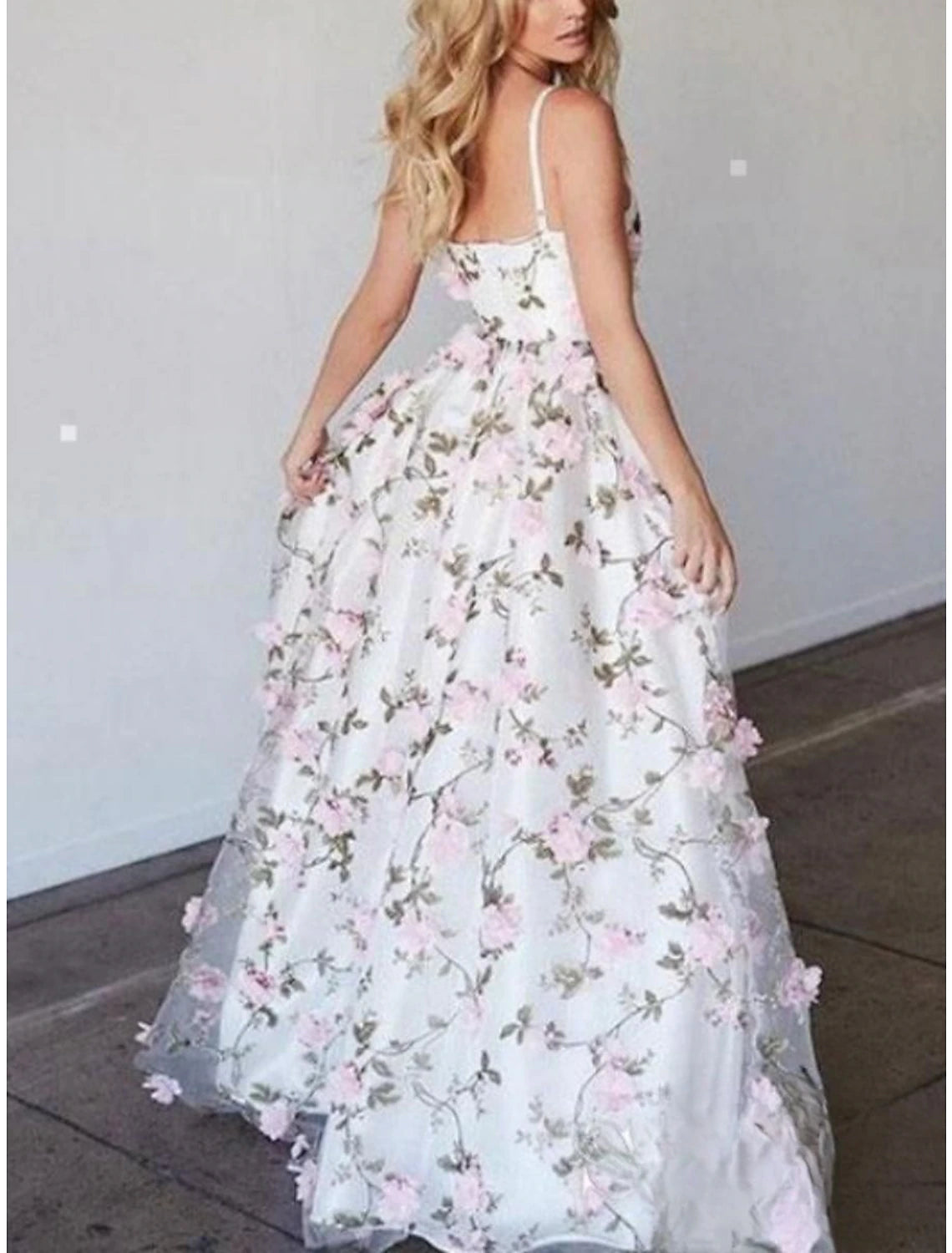 Back view of a floral lace sheath prom dress with spaghetti straps and sweep train.