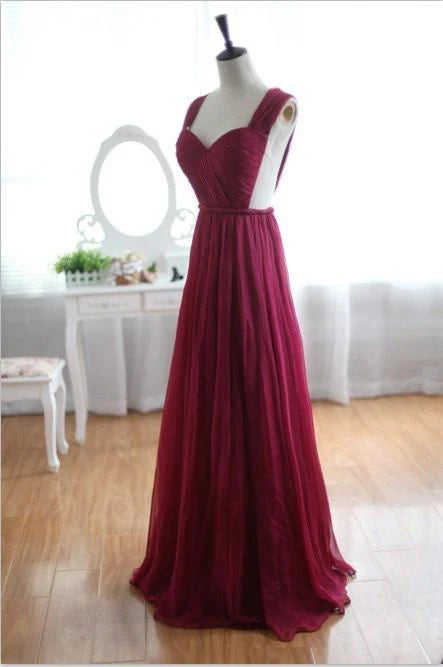 Back view of a woman in a flowing A-line V-neck prom dress.