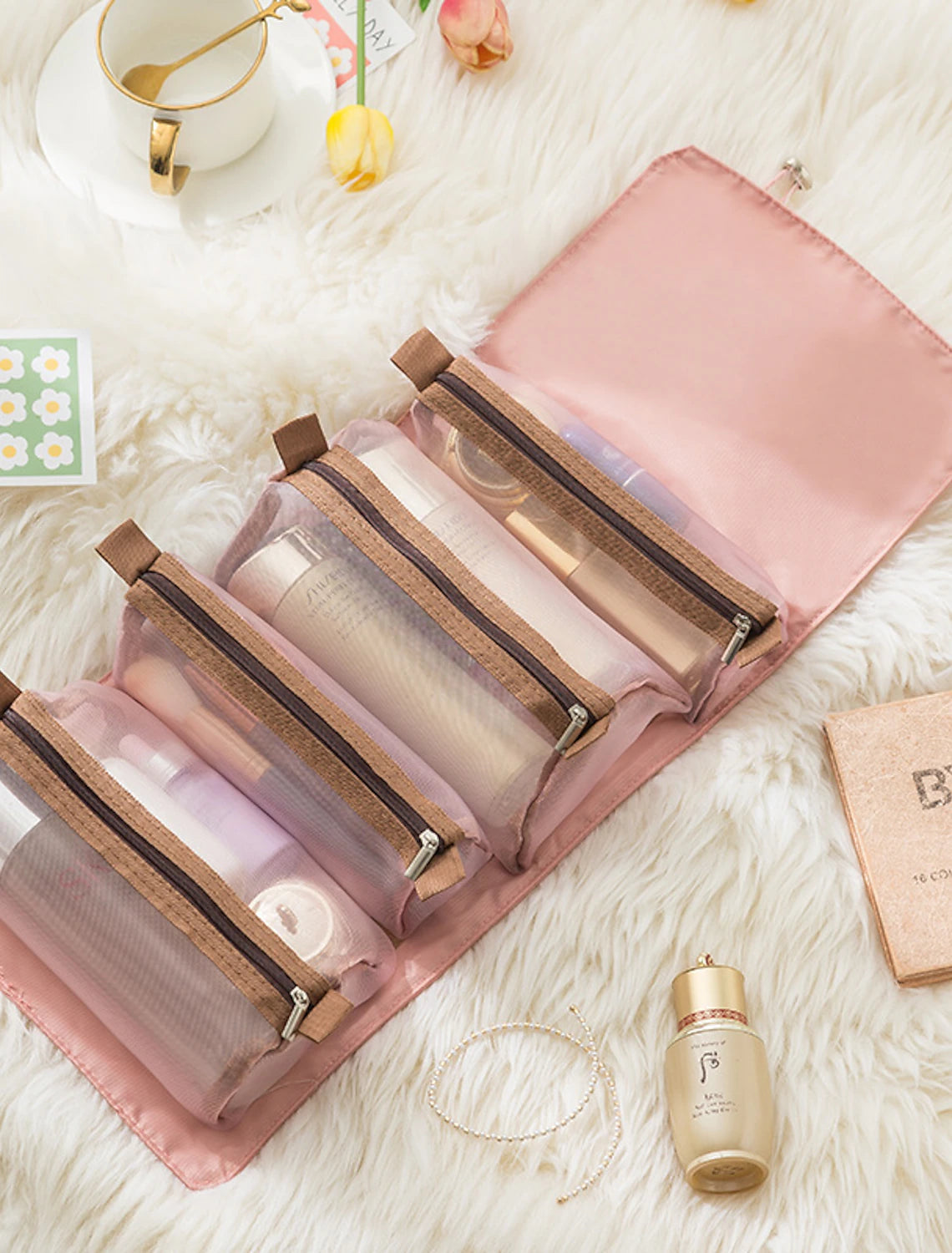 Foldable travel cosmetic bag, open showing multiple compartments.
