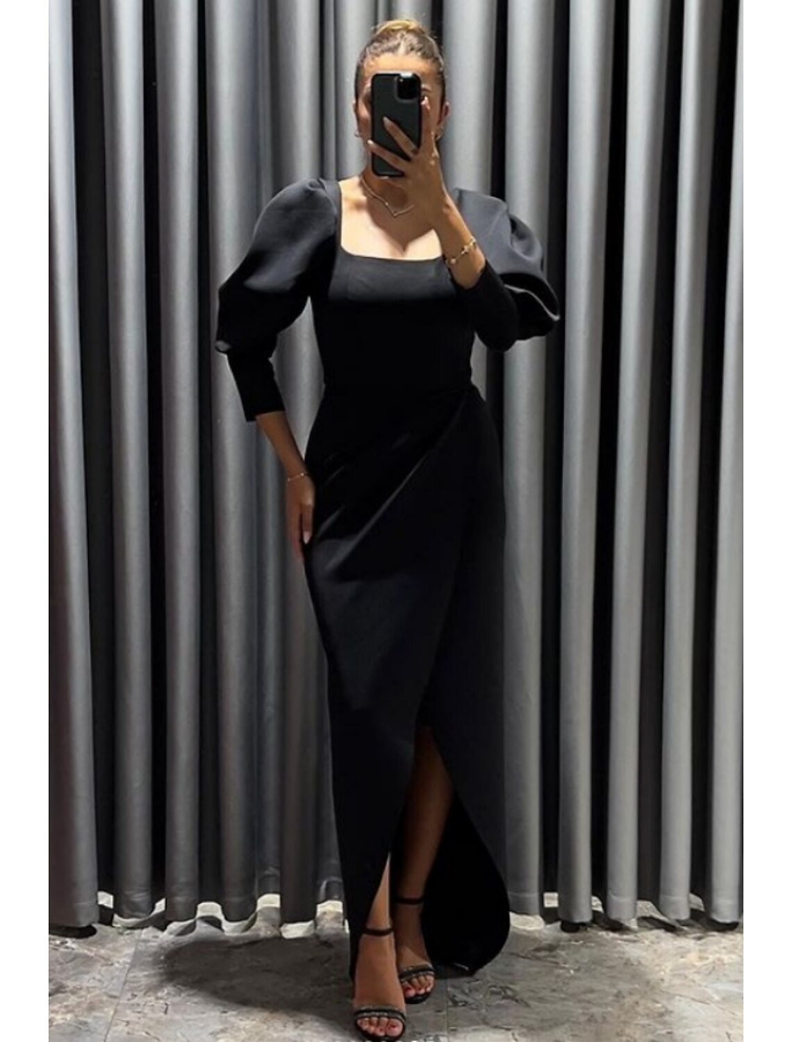Close-up of the square neckline and 3/4 length sleeves on the black dress.