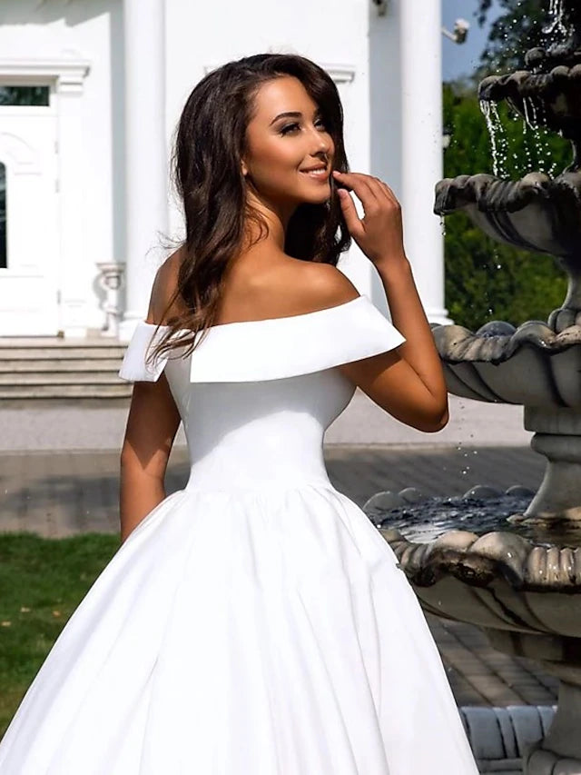 Back view of a formal satin wedding dress showing the chapel train.