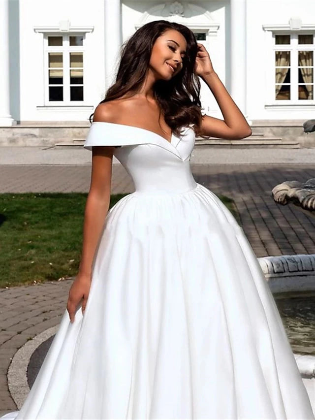 Close-up of the off-shoulder neckline and cap sleeves on a satin wedding gown.