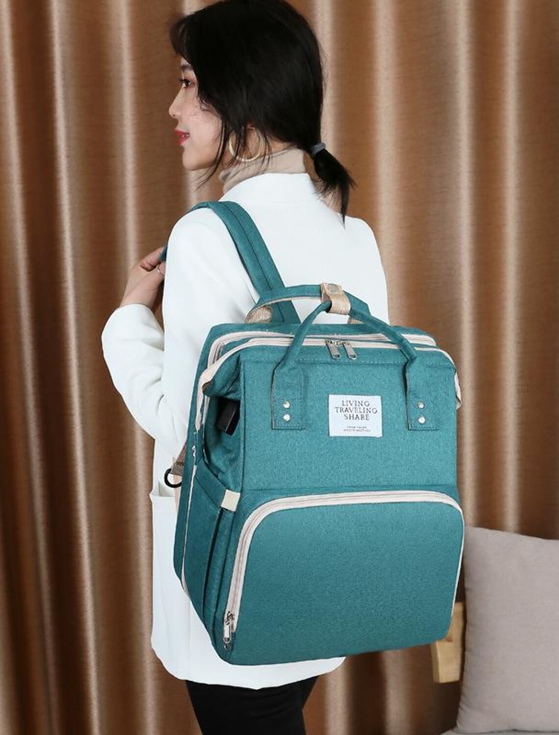 Person wearing a black unisex diaper bag backpack.