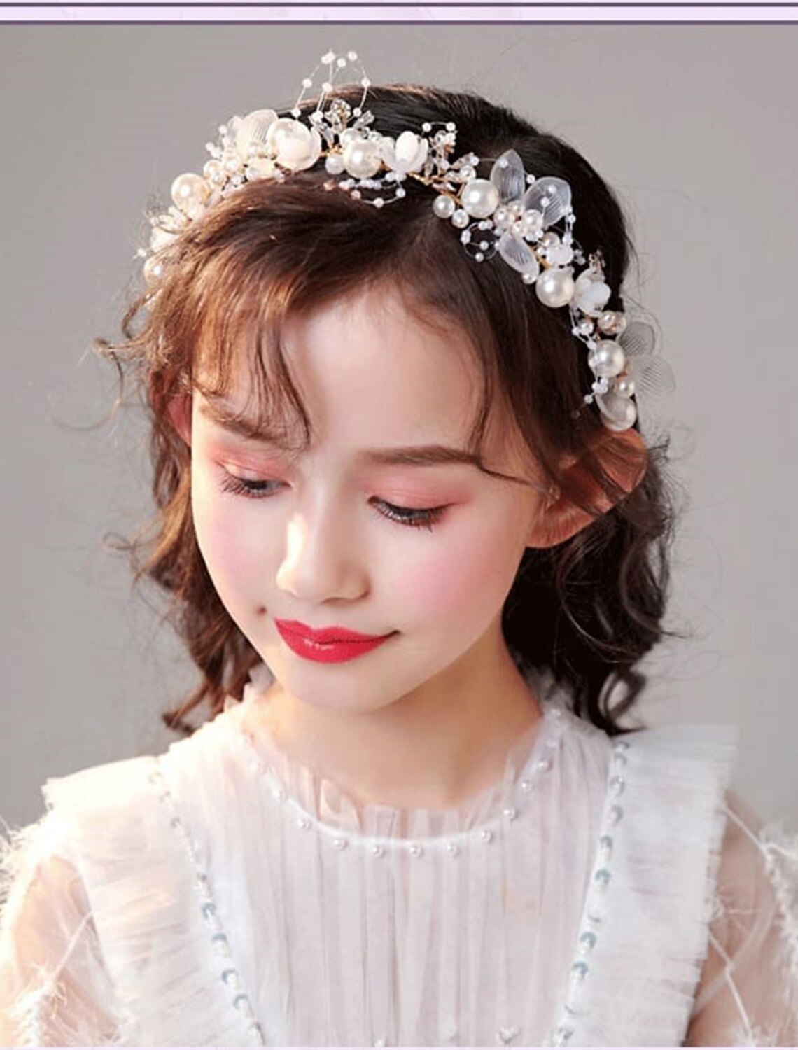 Girl wearing a white floral garland headband.