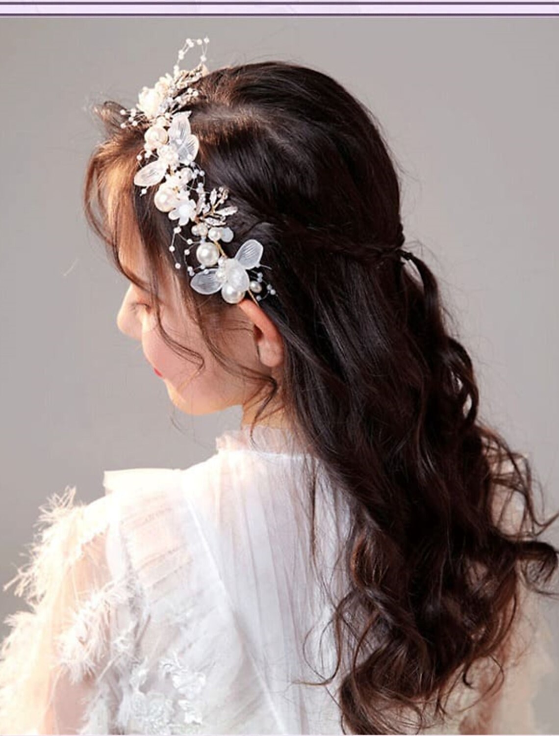 Side view of a girl wearing a white floral headband.