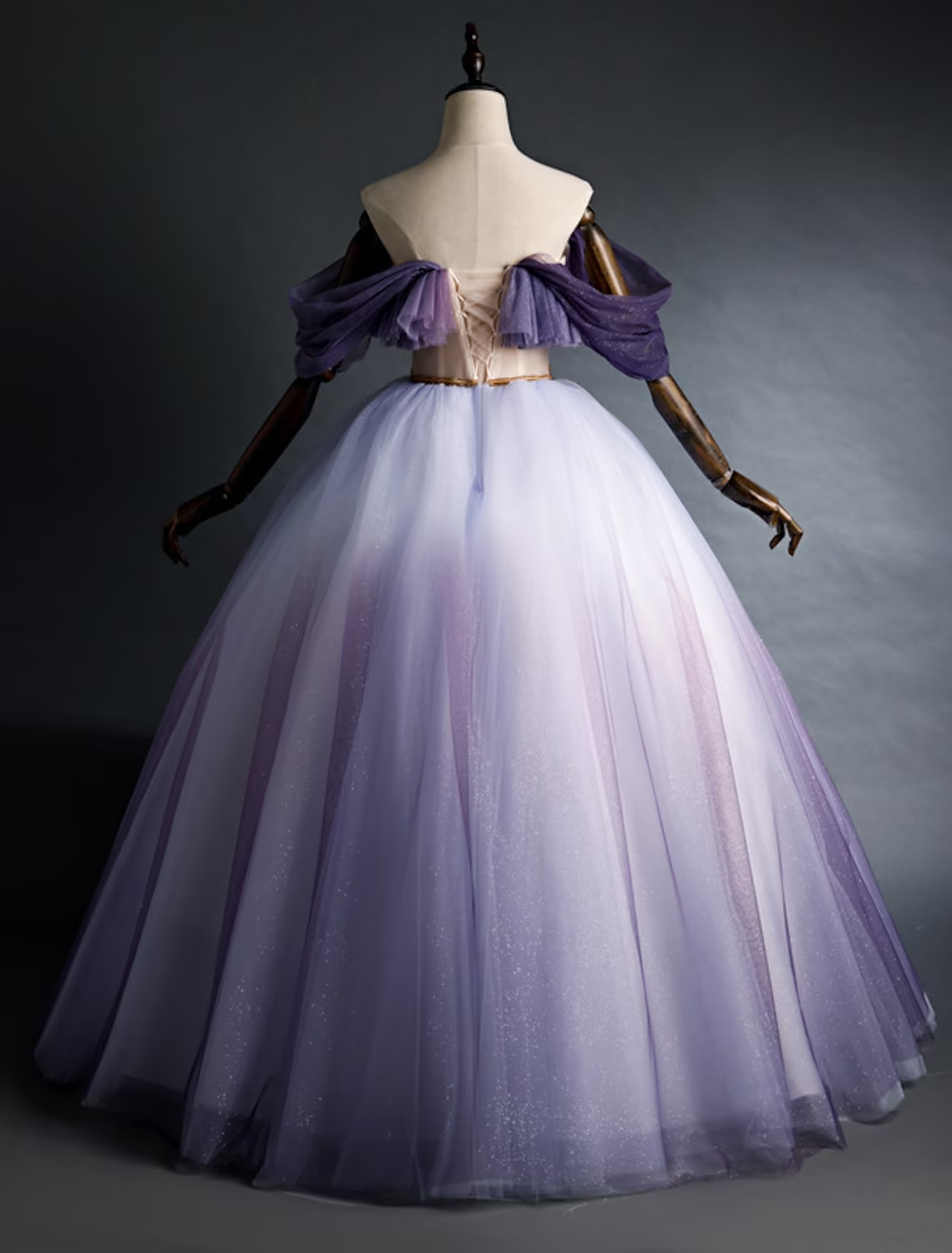 Side view of a girl in a purple ruched mesh off-shoulder dress.