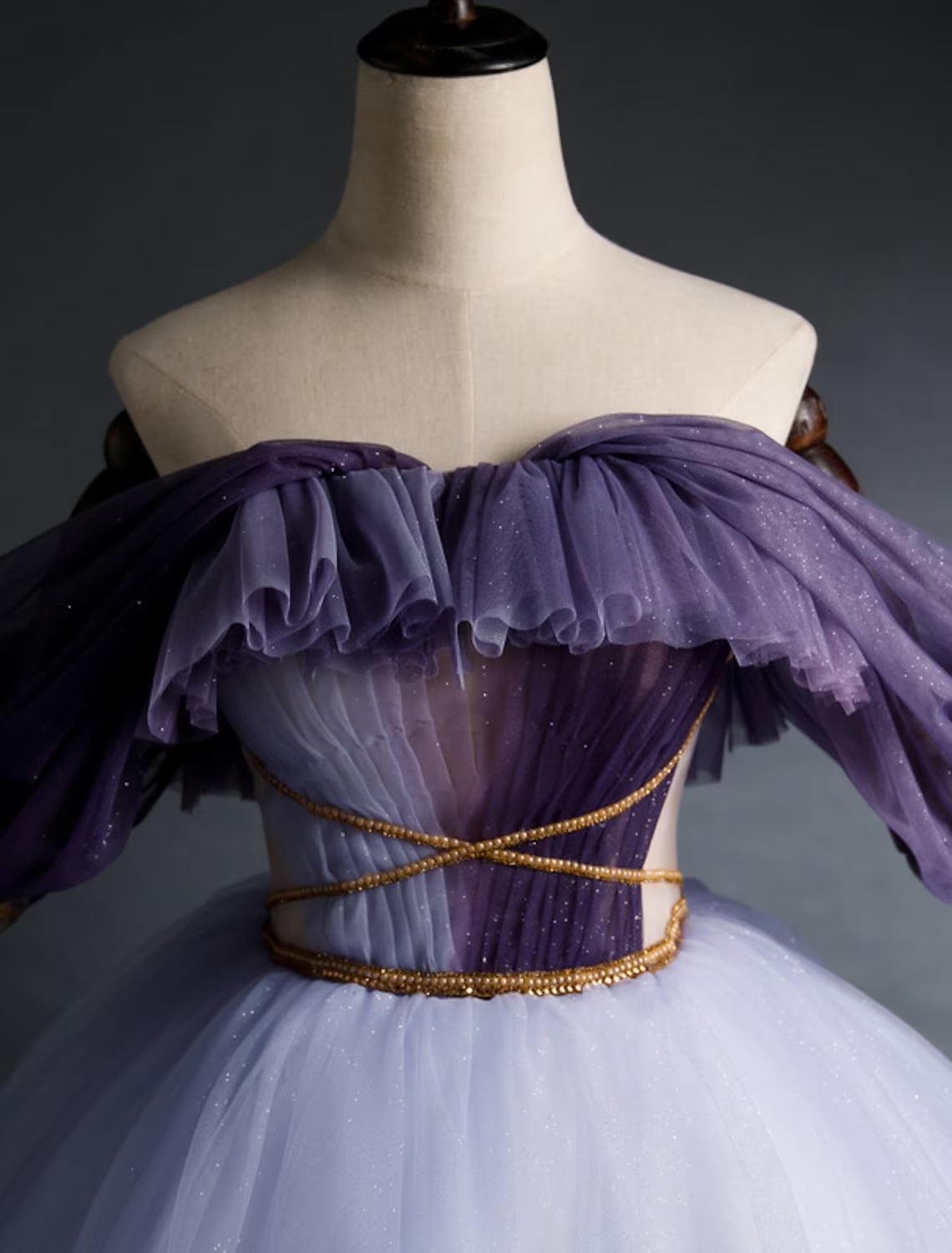 Back view of a girl in an asymmetrical purple tulle party dress.