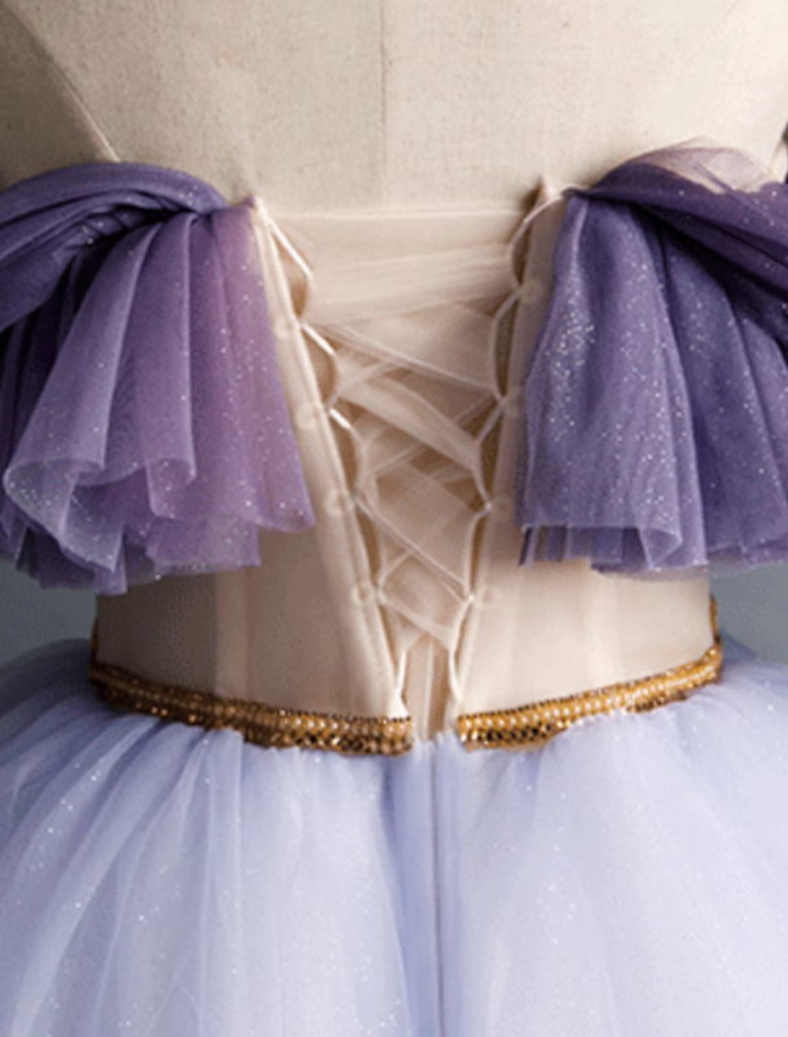 Close-up of the ruched mesh and tulle fabric on the purple dress.