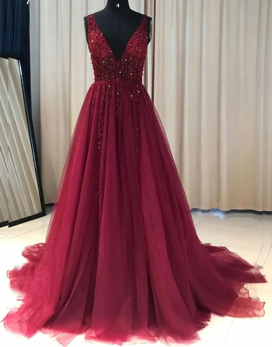 Woman wearing an elegant A-line deep V-neck long prom dress with intricate beading.