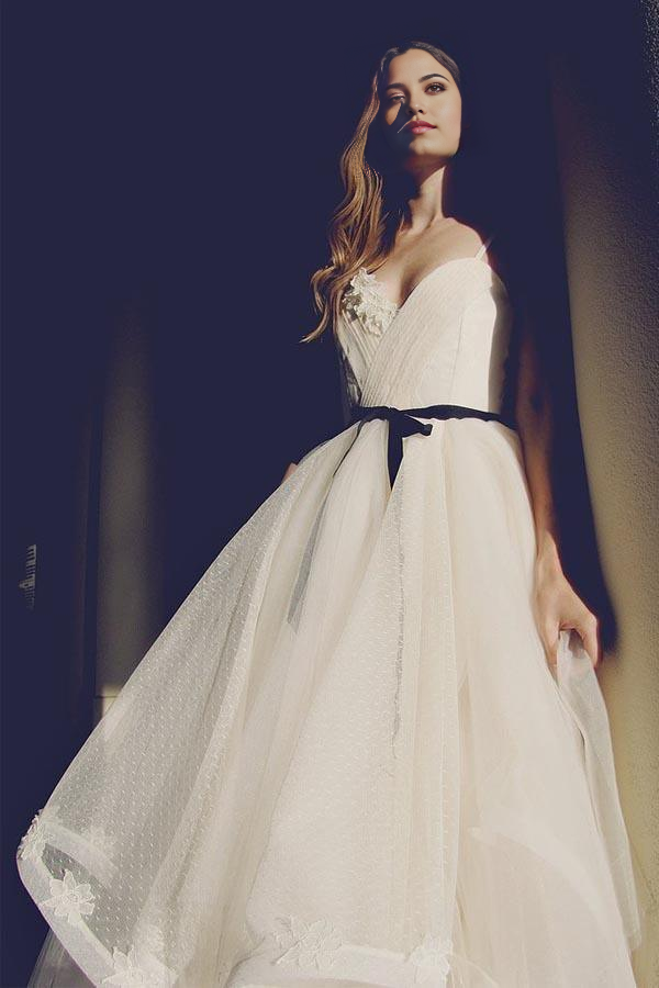 Front view of an elegant A-line ivory tulle wedding gown with V-neck and delicate straps.