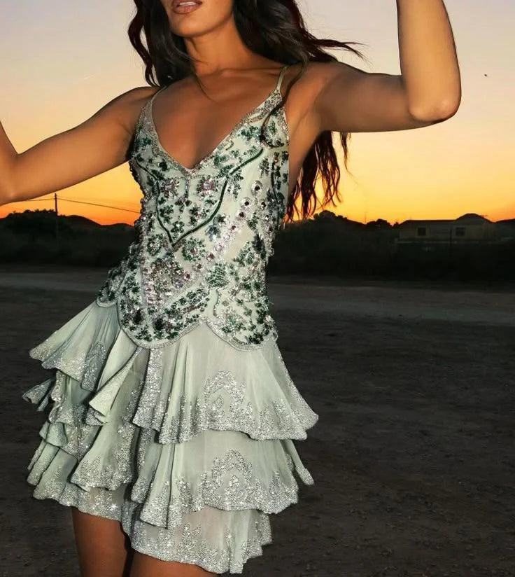 Side view of the green and silver mini dress highlighting the tiered ruffled skirt.