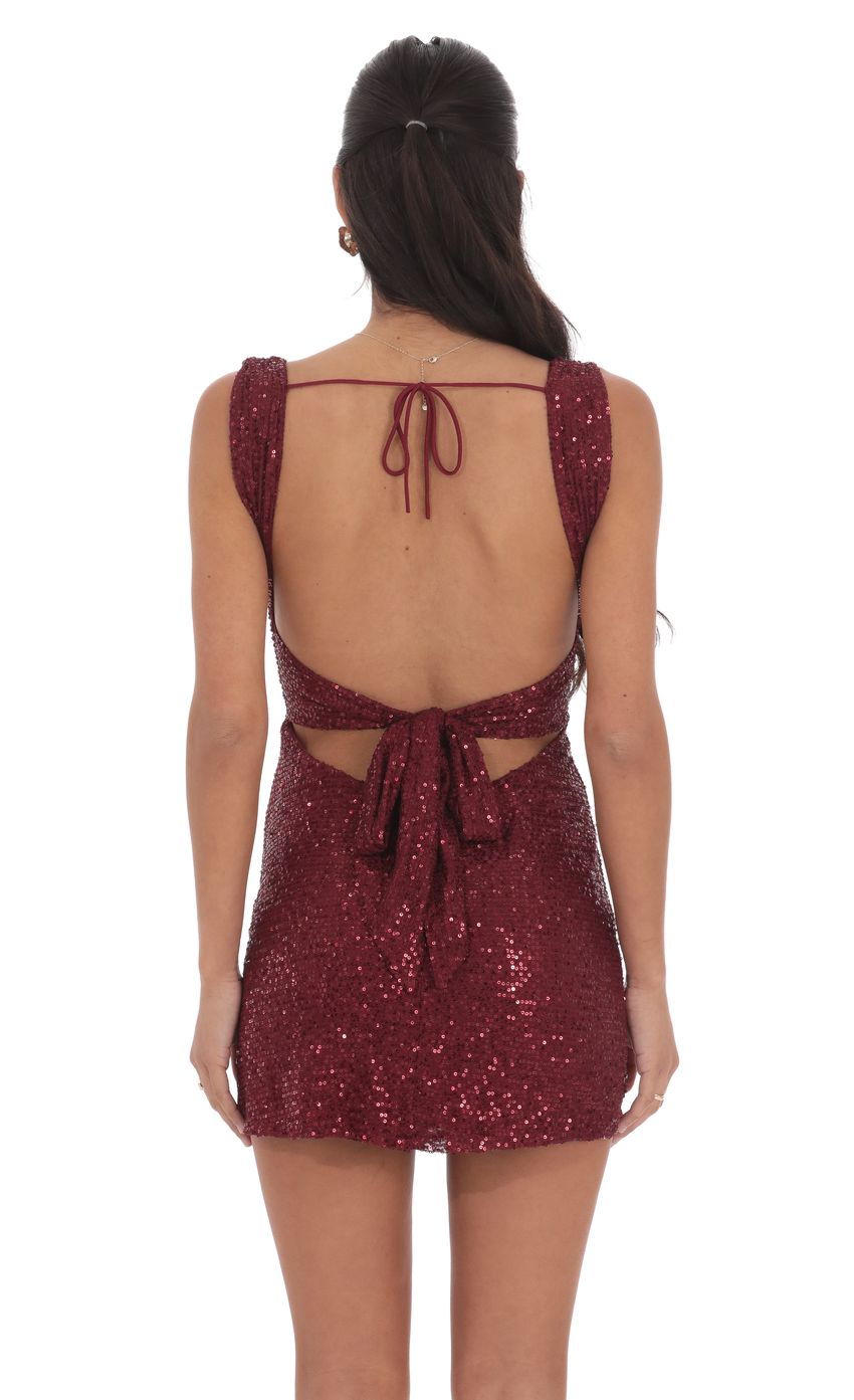 Close-up of the shimmering burgundy sequin fabric and square neckline of the dress.