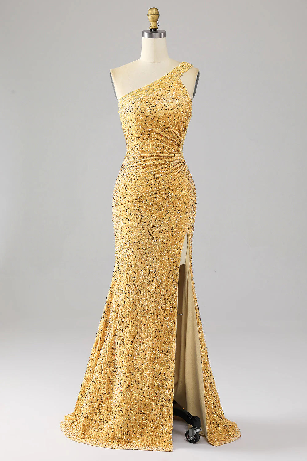 Model wearing a golden mermaid sequin one-shoulder prom dress with a high slit, posing elegantly.
