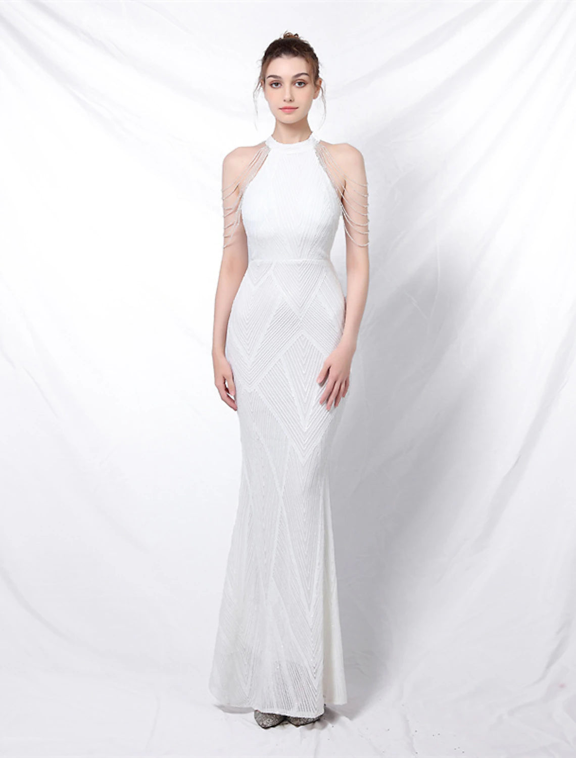 Model wearing a sparkly halter mermaid trumpet prom dress with sequins.