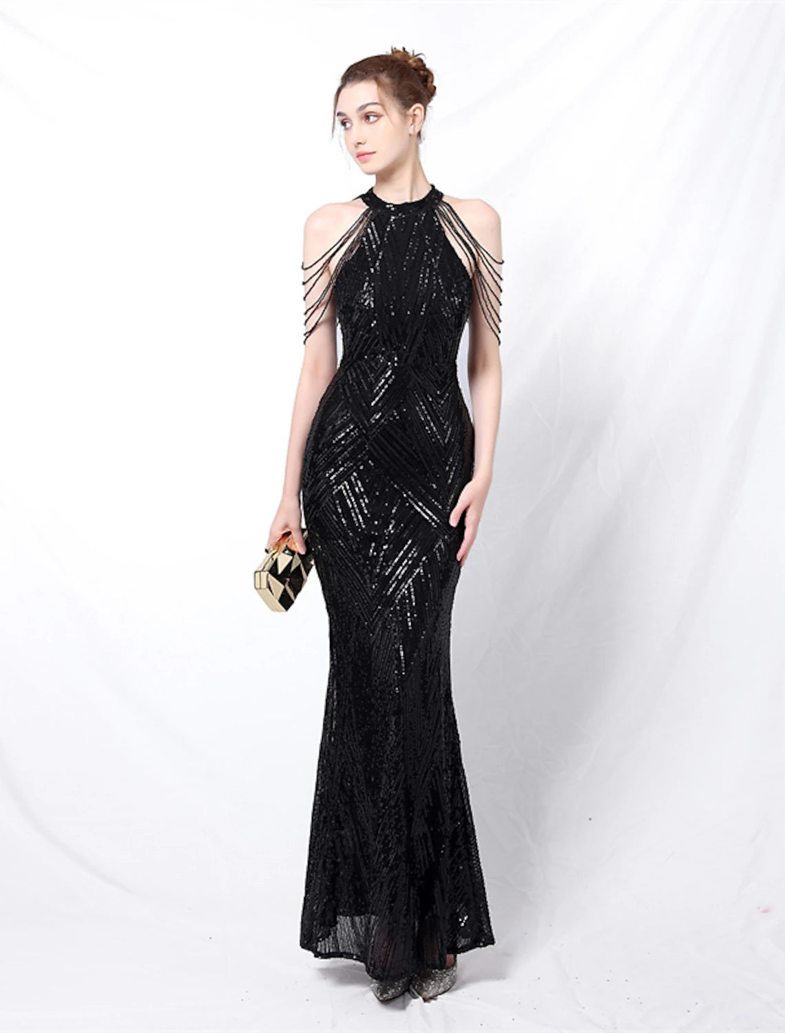 Side view of a woman in a floor-length sequined prom gown.