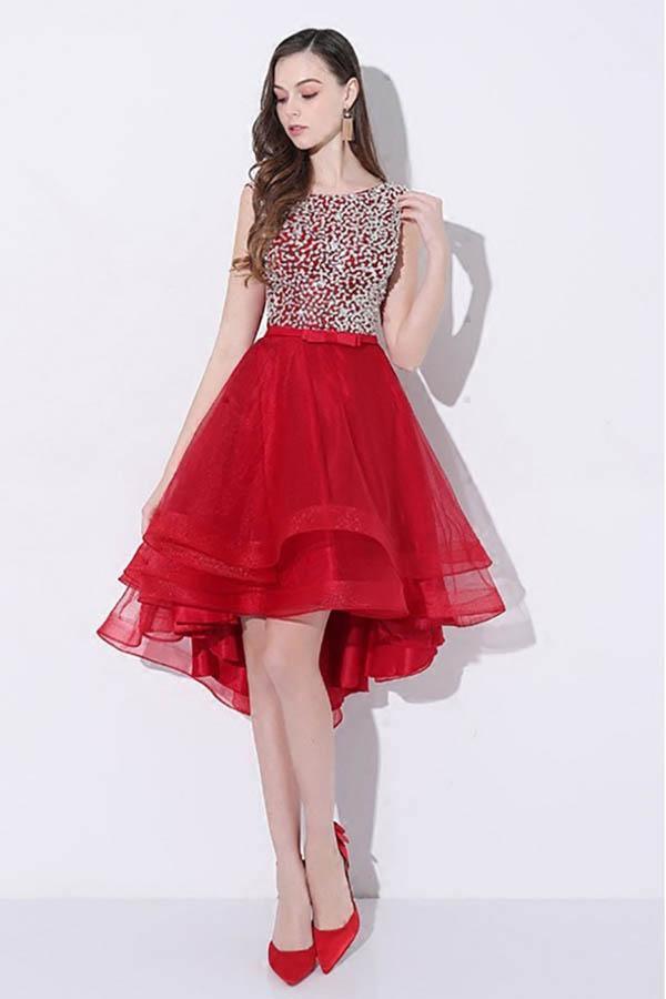 Model wearing a dazzling red sequin high-low prom dress with an open back and V-neckline.