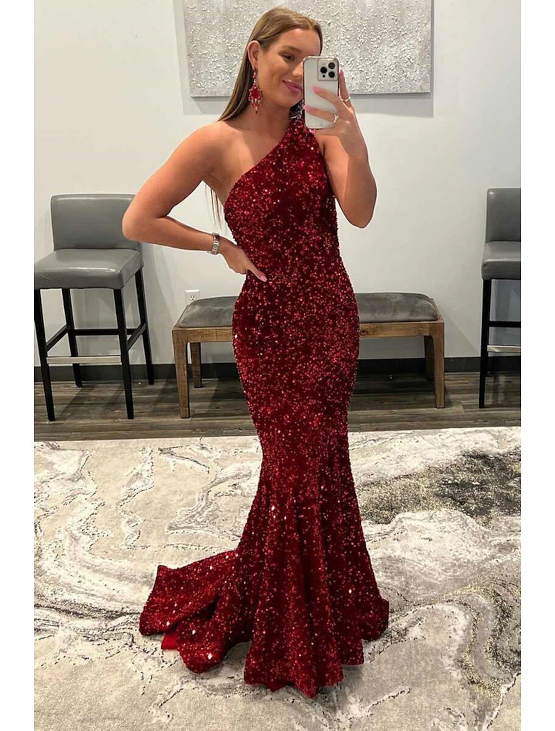 Model wearing a shimmering one-shoulder sequined mermaid prom dress with a floor-length silhouette.