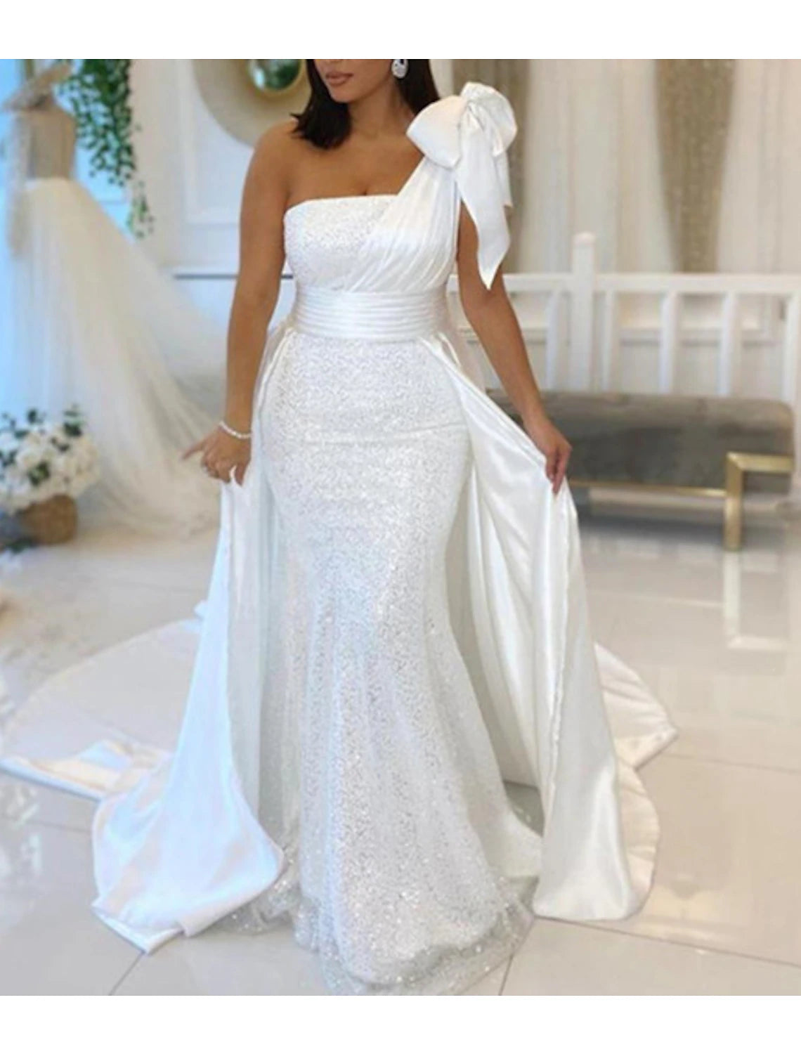 Side view of a navy blue mermaid gown, showcasing the court train and ruched sequin embellishments.