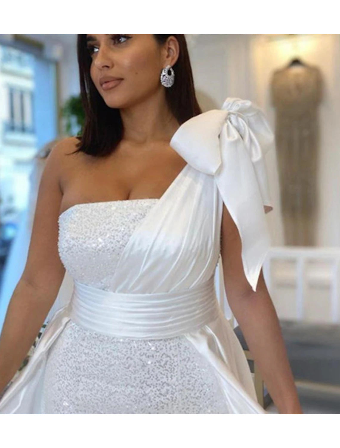 Back view of a navy blue one-shoulder mermaid evening gown with a flowing court train.