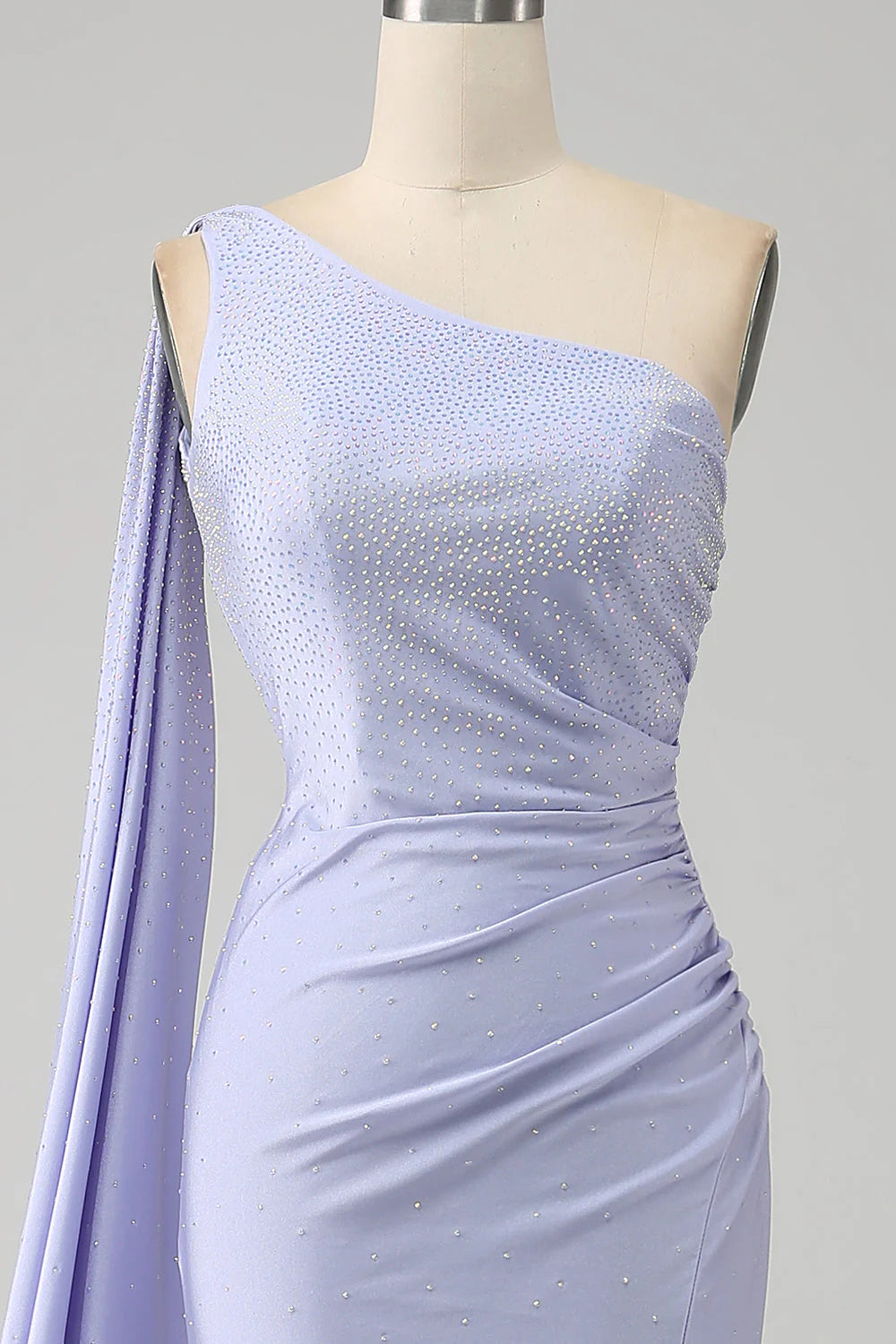 Side profile of the long formal dress with a flowing skirt.