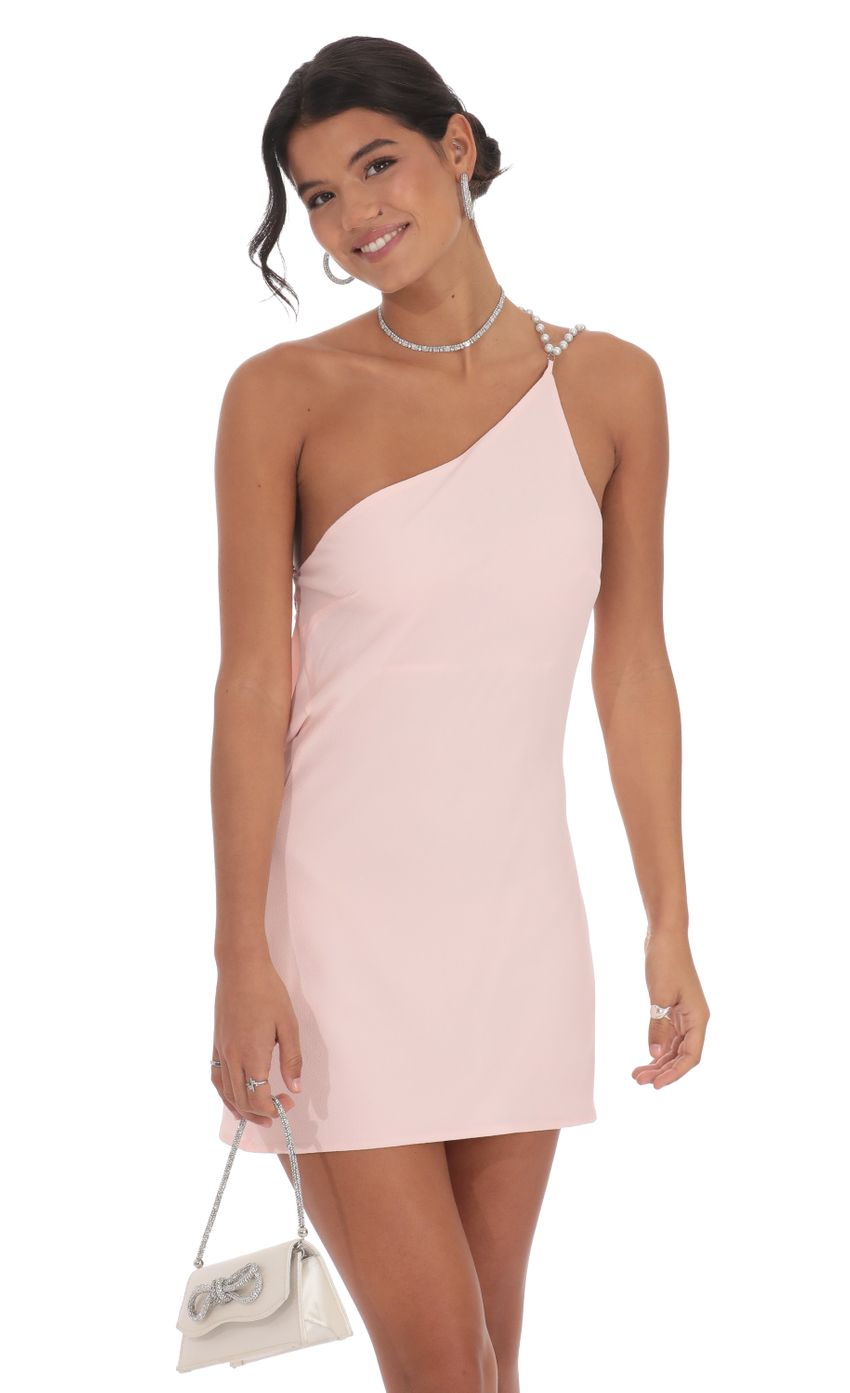 Model posing in a glamorous pearl one-shoulder mini dress.