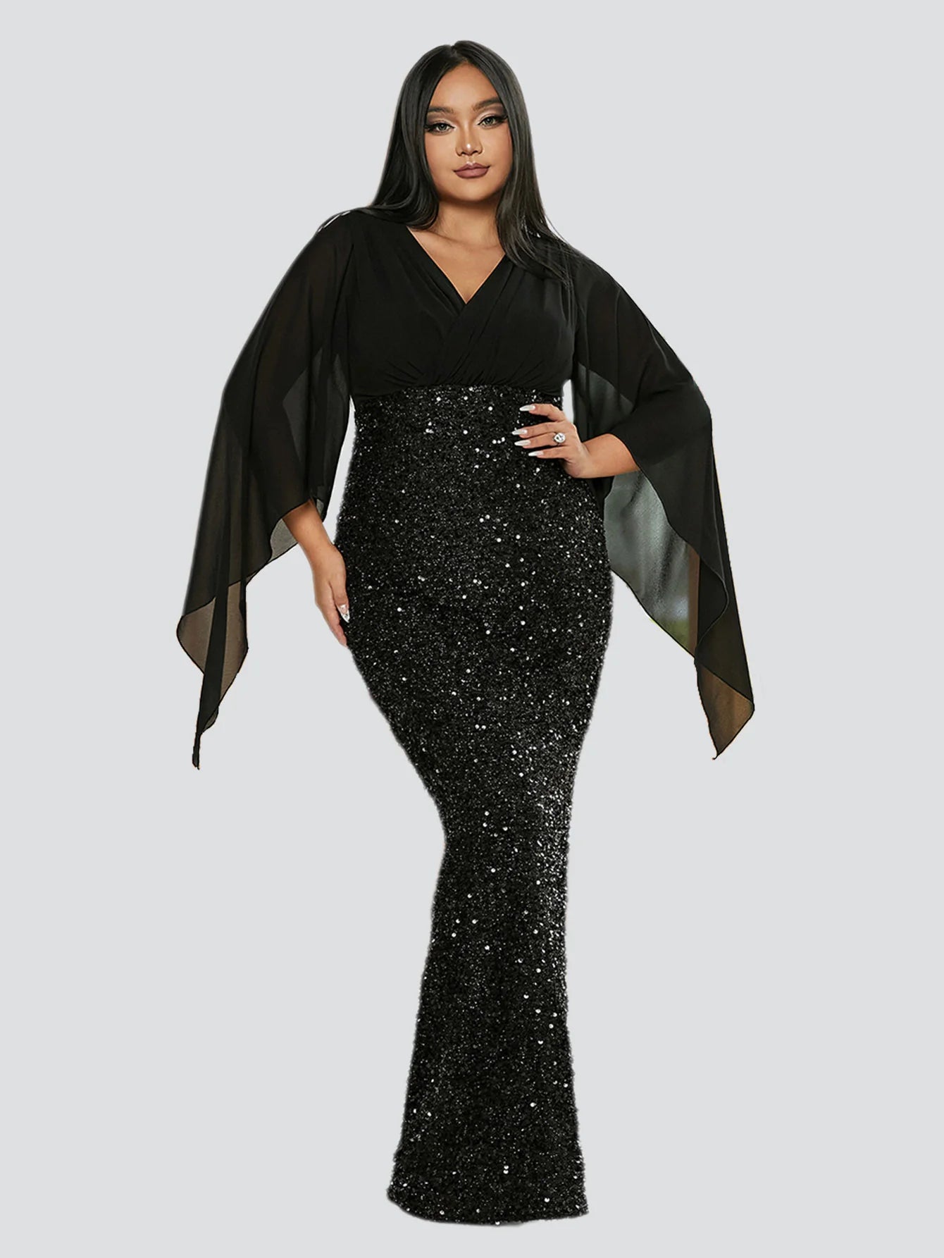 Model posing in a plus size sequined long sleeve V-neck gown.