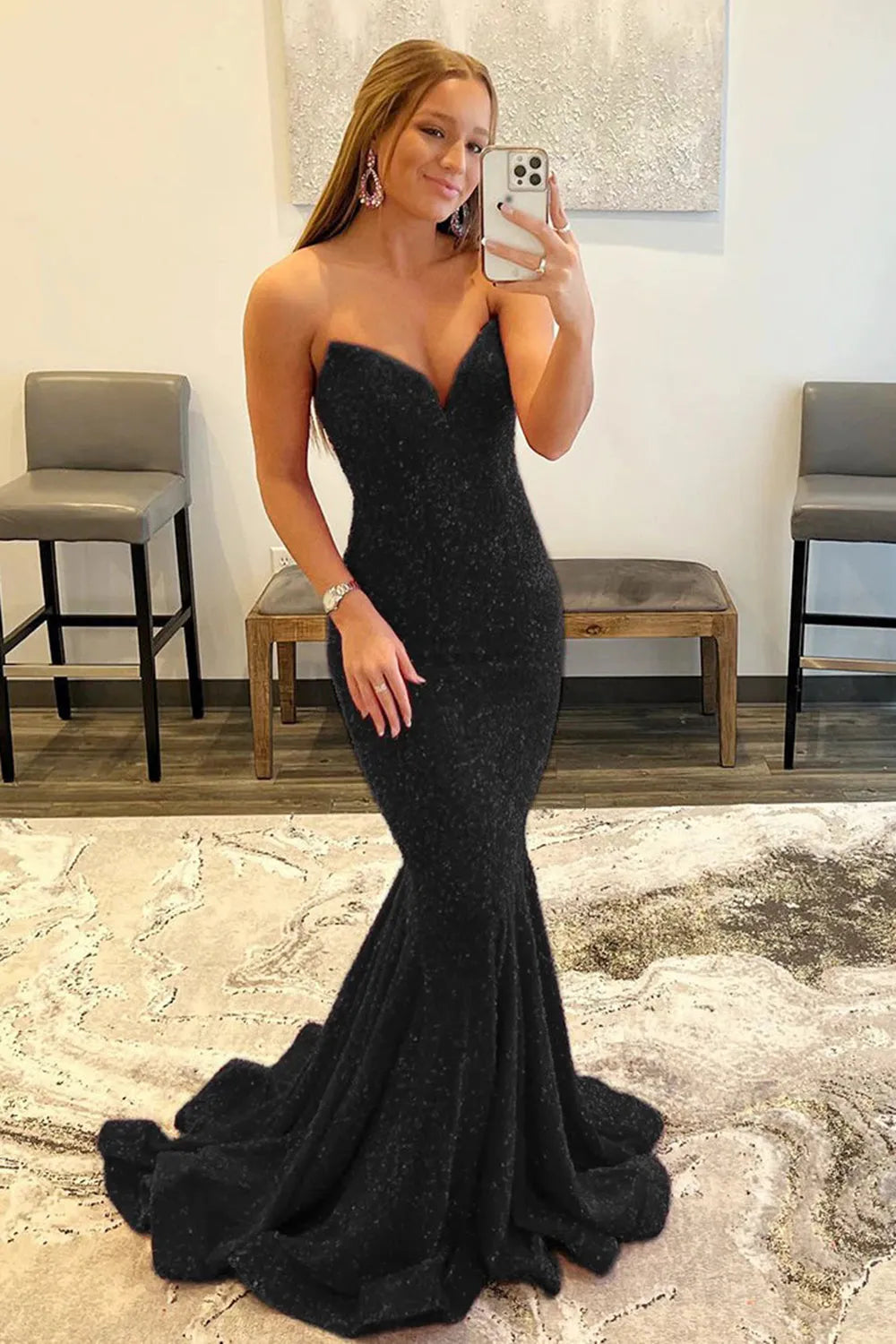 Model wearing a shimmering sequined mermaid prom dress with a sweetheart neckline and sweep train.