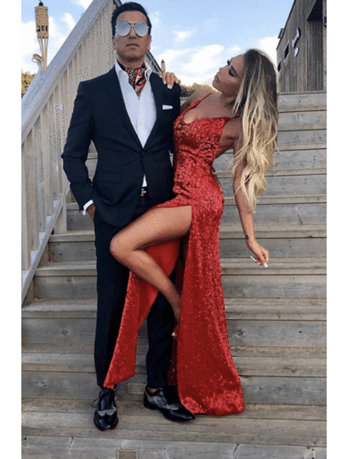 Woman in a shimmering sequined mermaid prom dress with a court train.