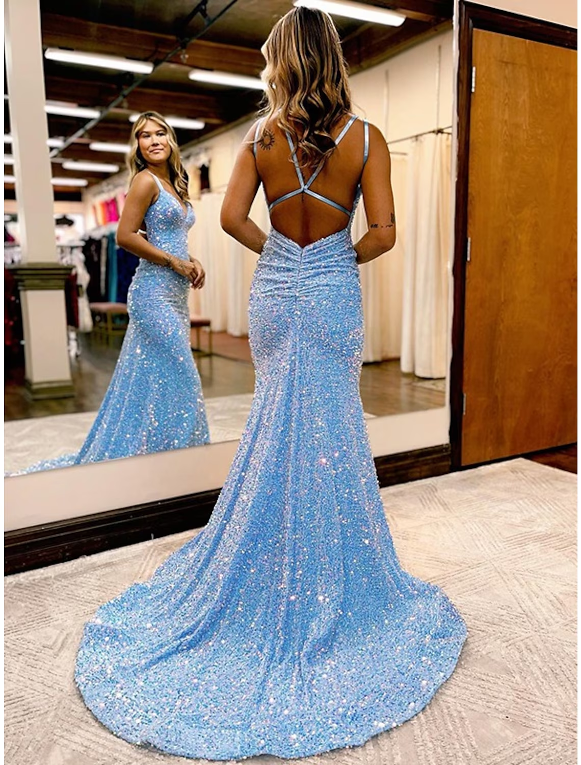 Back view of a woman in a dark velvet sequin formal dress, highlighting the sweep train.
