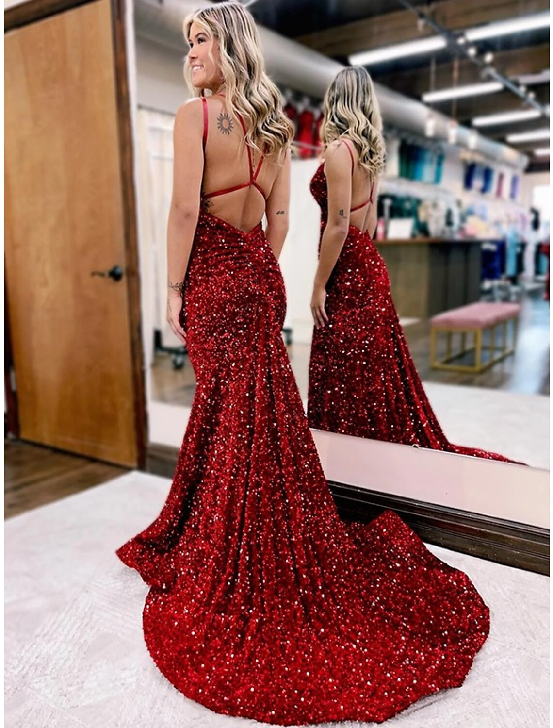 Side view of a woman in a dark velvet sequin V-neck gown, showing ruched details.