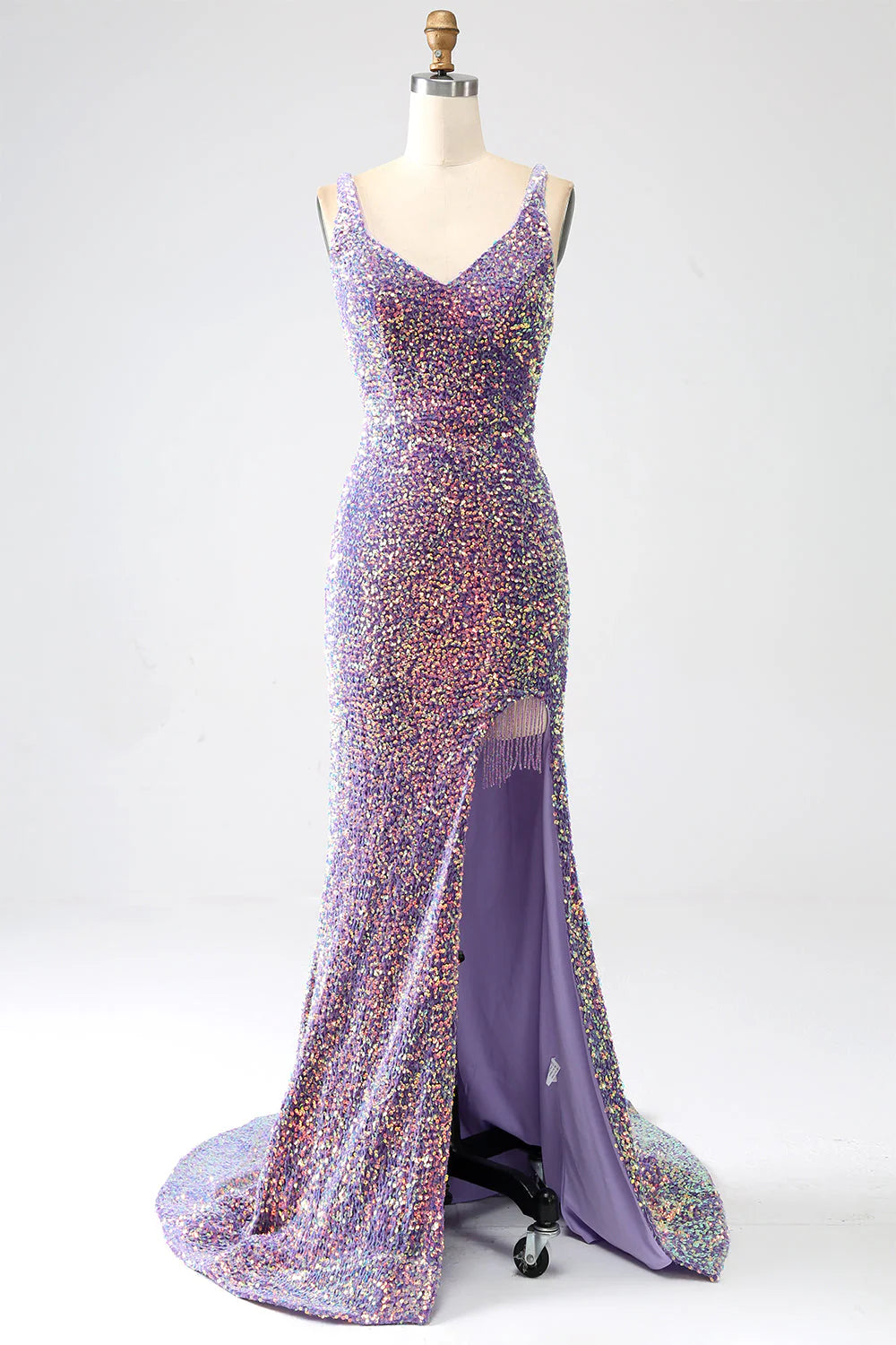 Woman wearing a light purple mermaid sequined prom dress with a high slit.