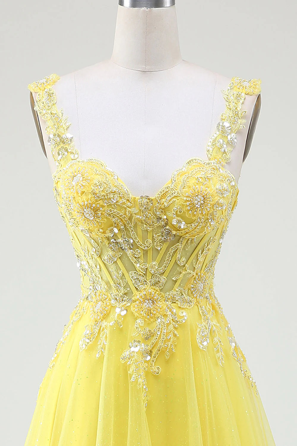 Side view of the yellow beaded prom gown, highlighting the flowing tulle skirt.