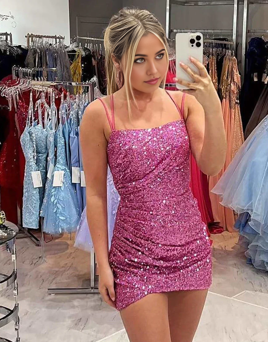 Woman posing in a sparkling A-line sequin gown with spaghetti straps.