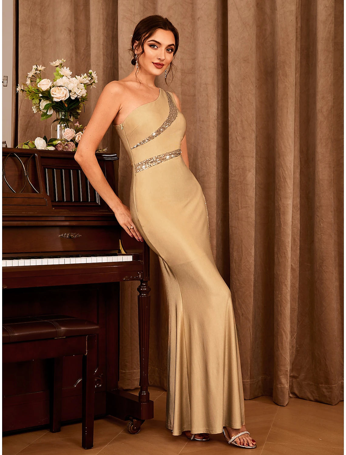 Side profile of the elegant floor-length party gown with glitter detail.