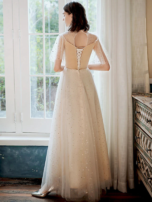 Model posing in a glittering A-line high neck half sleeve sequin tulle ankle length prom dress.