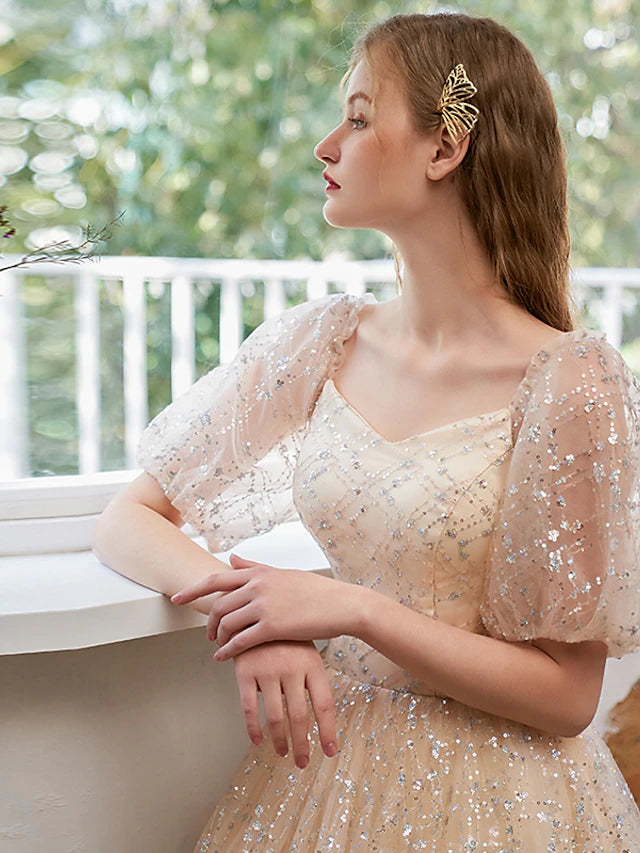Back view of a floor-length sequin tulle evening gown.