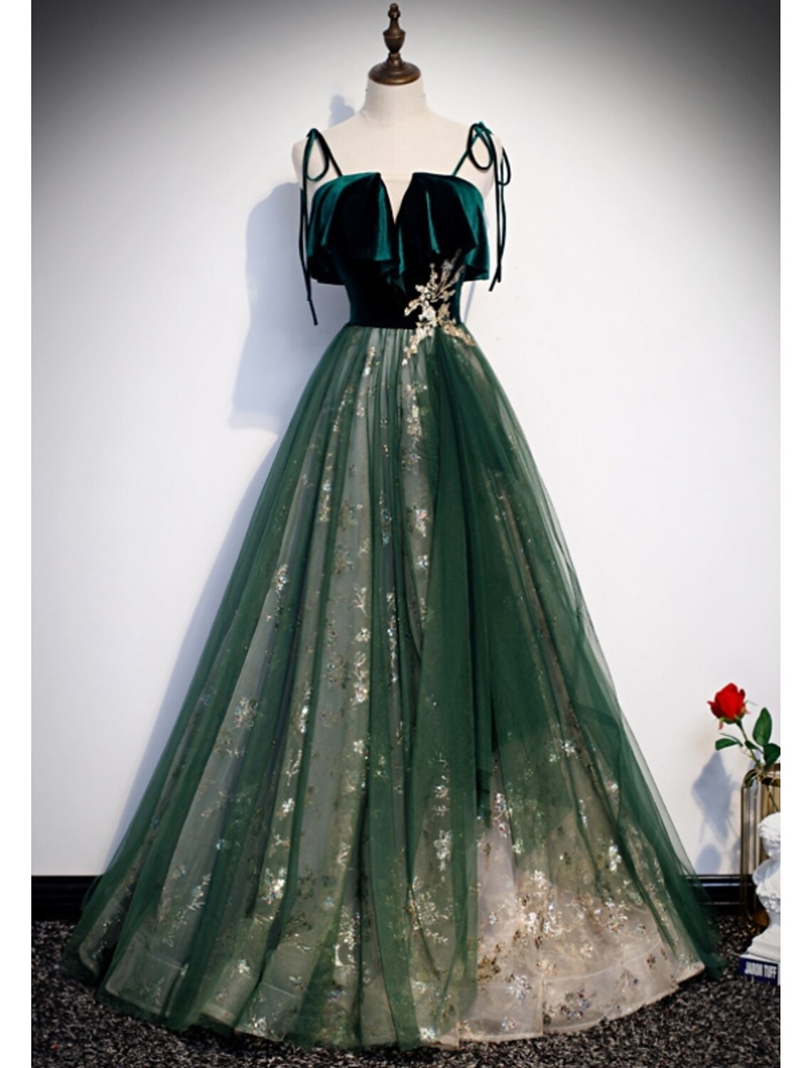 Model wearing a glittering A-line prom dress with spaghetti straps.