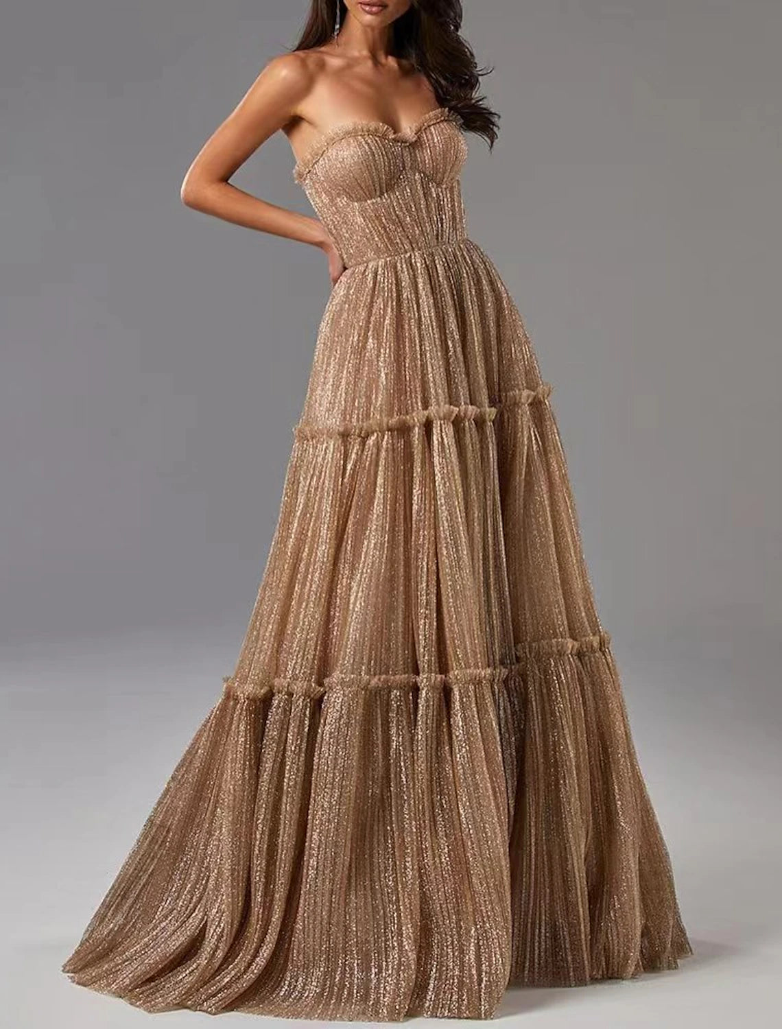 Woman wearing a glittering A-line strapless evening gown.