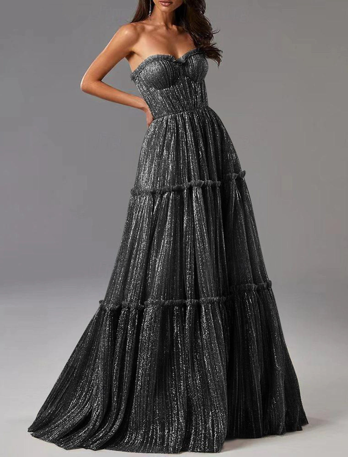 Side view of a woman posing in the strapless A-line formal dress.