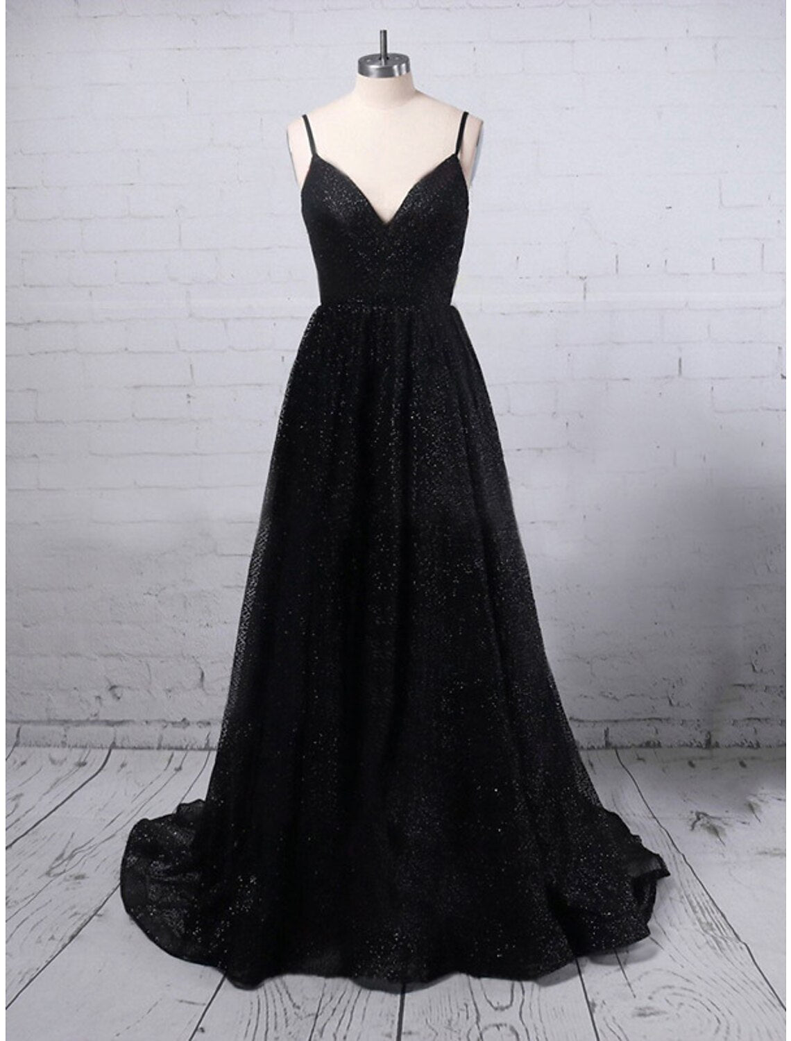 Woman wearing a glittering A-line V-neck sequined prom dress with a high slit.