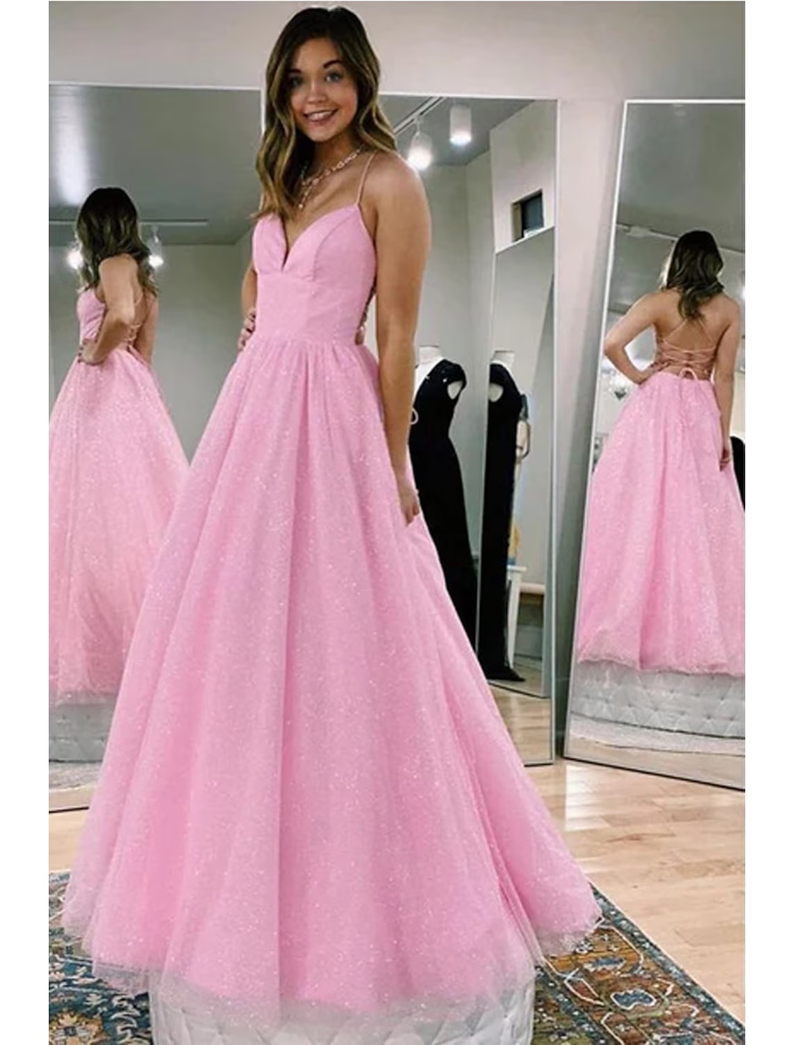 Model wearing a glittering A-line V-neck tulle ball gown prom dress.