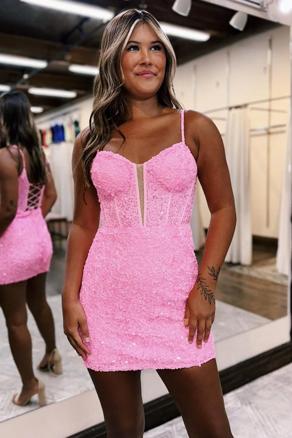 Back view of a model wearing a sparkling short formal dress.