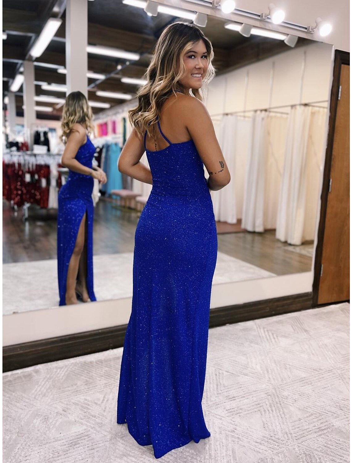 Side profile of a glittering mermaid trumpet prom dress, highlighting the floor-length silhouette.