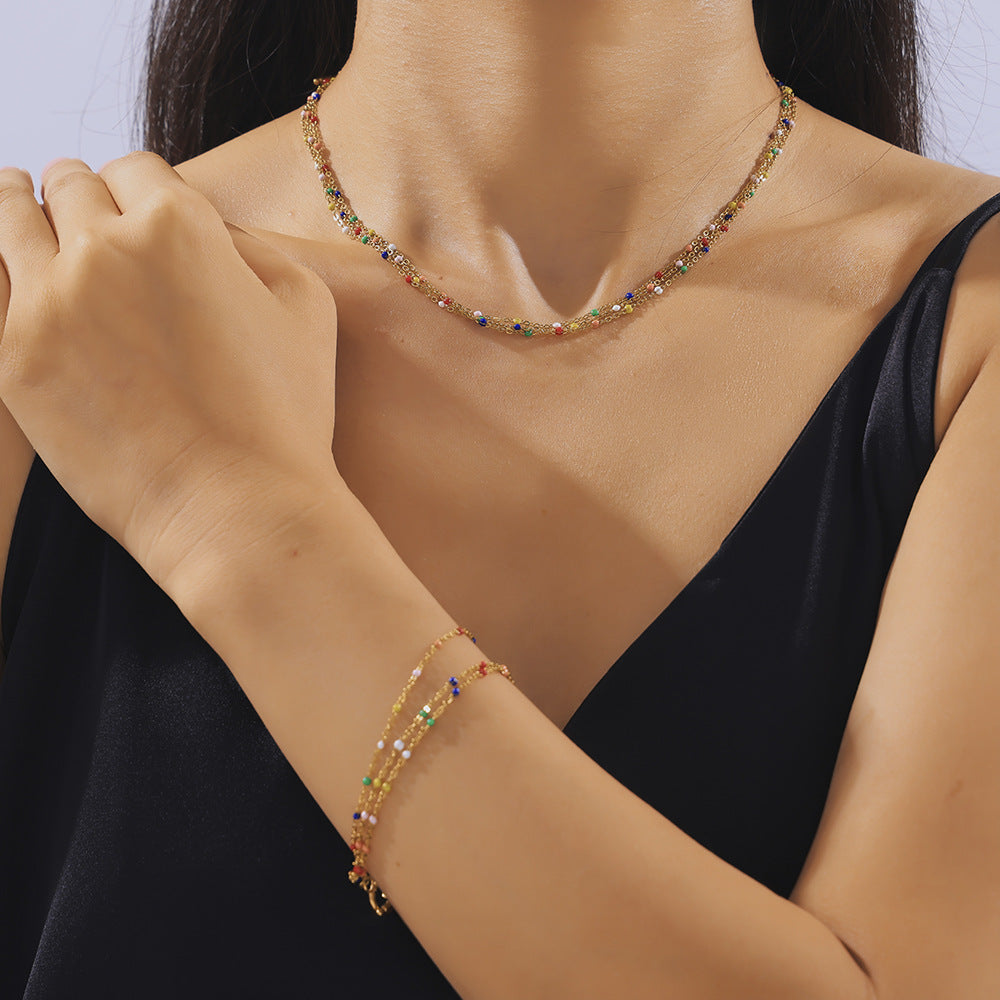 Model wearing a gold-plated titanium steel multi-layer necklace and bracelet set.