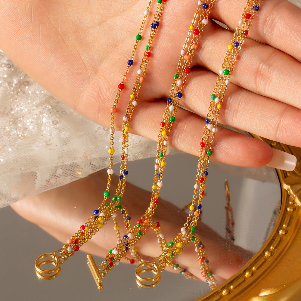 Stylish model showcasing the gold-plated titanium steel multi-layer jewelry set.