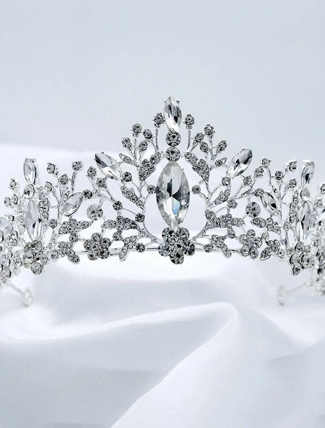 Golden crystal tiara crown displayed on a stand.